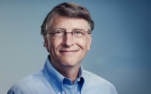 Homem sorridente vestindo uma camisa azul, usando óculos e com expressão amigável, posando diante de um fundo neutro. A imagem transmite profissionalismo e carisma.