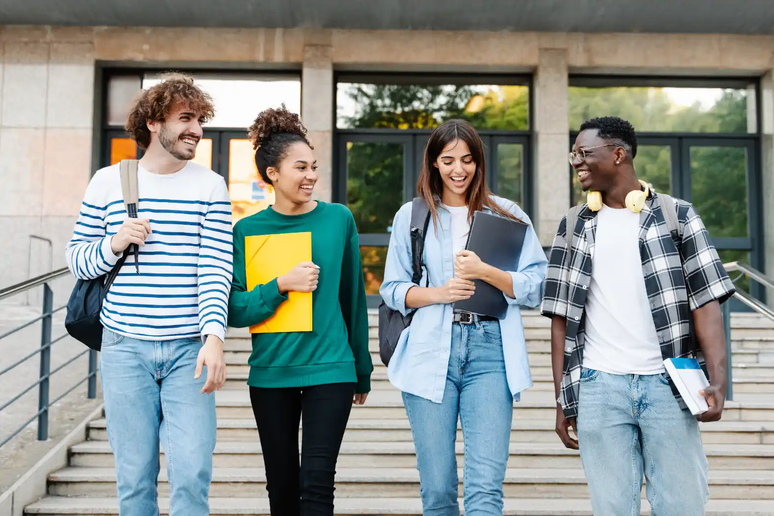 Grupo de estudantes caminhando juntos na universidade com pastas e livros, sorrindo e conversando em ambiente externo, tema relacionado ao Curso de Administração e preparação profissional.