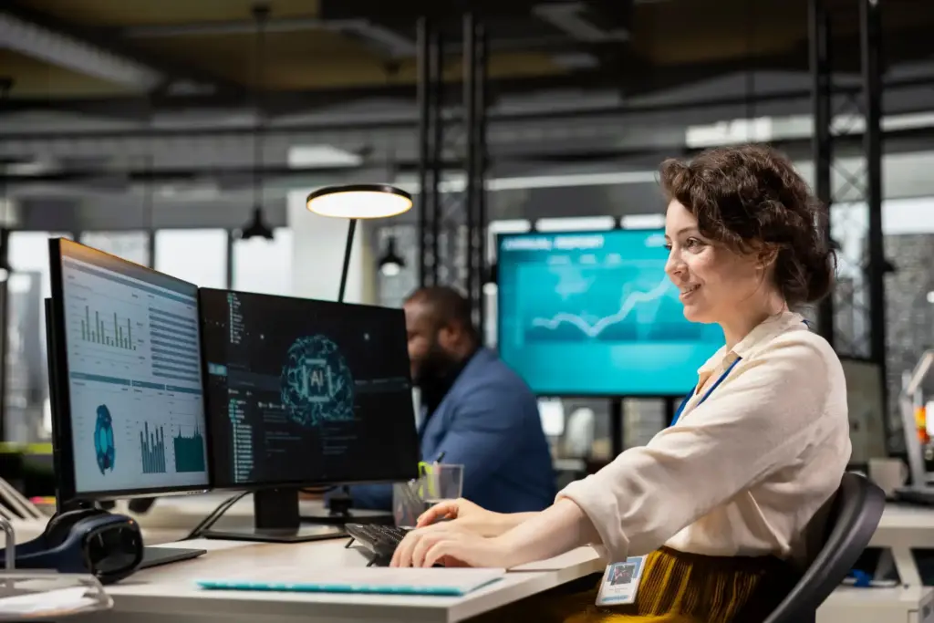 Ambiente de escritório com inteligência artificial, pessoas trabalhando com vários monitores e gráficos, evidenciando inovação e tecnologia com IA.