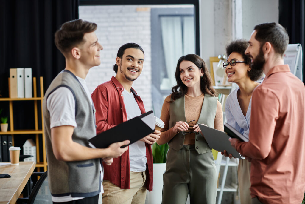 Profissionais conversando e colaborando em equipe no escritório, representando as habilidades mais valorizadas pelo mercado de trabalho atual como comunicação e trabalho em equipe.