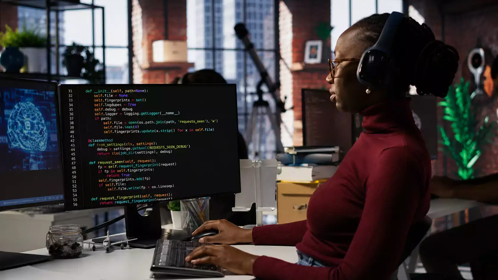 O que é machine learning. Profissional com headset em um escritório, trabalhando em frente a monitores com código de programação.